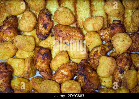 Ailes de poulet, pommes de terre et fromage frits cuits au four Banque D'Images