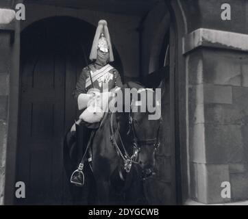 Années 1960, historique, une garde de la vie de la reine, en uniforme et épée cérémoniels, assis sur son cheval en service de garde à l'entrée de Horse Guards sur Whitehall à Londres, Angleterre, Royaume-Uni. La Garde de la Reine est assurée par des hommes du régiment monté de cavalerie de la maison et est présente depuis la restauration de la monarchie et du roi Charles II en 1660. Banque D'Images