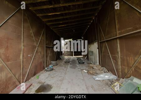 L'intérieur d'un vieux garage abandonné avec métal rouillé murs Banque D'Images