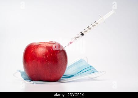 Une seringue est l'injection d'une pomme, symbolique de la vaccination et du traitement médical Banque D'Images