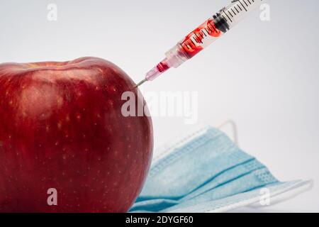 Une seringue est l'injection d'une pomme, symbolique de la vaccination et du traitement médical Banque D'Images