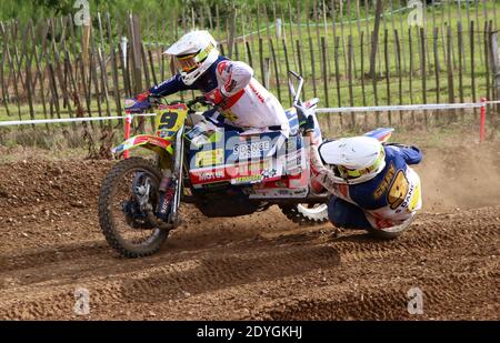 des tenues de side-car volent autour d'un bens sur une piste de motocross comme ils prennent un virage Banque D'Images