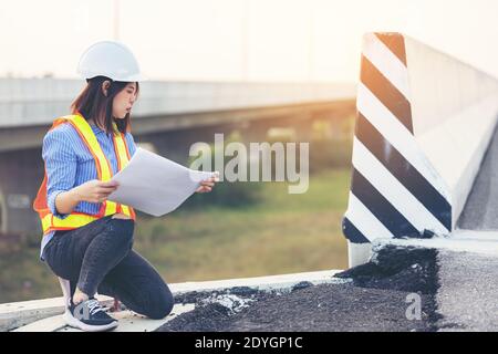 Portrait d'un ingénieur faisant un geste sur une route endommagée, les travailleurs de la route inspectant la construction Banque D'Images