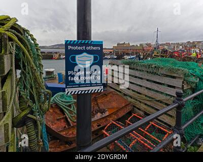 Covid -19, affiche d'avertissement parmi les équipements de pêche à Scarborough, dans le North Yorkshire Banque D'Images