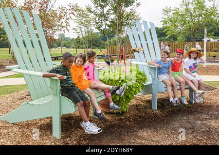 Huntsville Alabama, jardin botanique jardin extérieur pour enfants, Black boy Girls géant Adirondack chaises assis, Banque D'Images