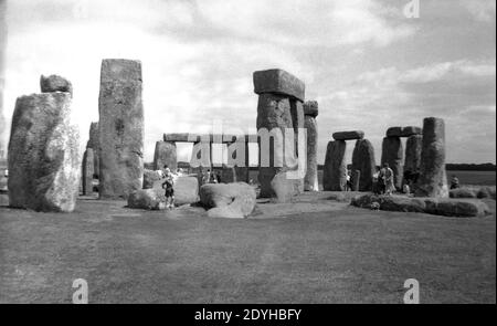 Années 1950, historique, visiteurs au célèbre monument ancien de Stonehenge, Wiltshire, Angleterre, Royaume-Uni, un anneau préhistorique de pierres debout estimé à être construit entre 3000 et 2000 av. J.-C. On pense que la région était à l'origine un ancien cimetière. Dans cette époque, les visiteurs pouvaient marcher librement parmi les pierres, mais les inquiétudes sur l'érosion ont vu cela prendre fin en 1977 quand l'accès à elles a été rodé. Banque D'Images