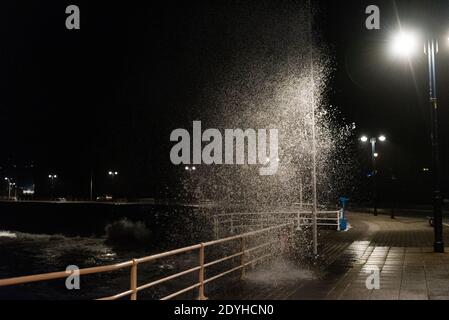 Storm Bella s'écrase contre la promenade d'Aberystwyth lors d'un serrage de 4.2 mètres de haut le soir du lendemain de Noël. Banque D'Images