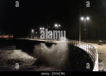 Storm Bella s'écrase contre la promenade d'Aberystwyth lors d'un serrage de 4.2 mètres de haut le soir du lendemain de Noël. Banque D'Images