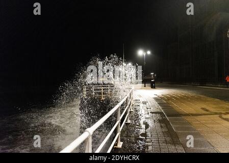 Storm Bella s'écrase contre la promenade d'Aberystwyth lors d'un serrage de 4.2 mètres de haut le soir du lendemain de Noël. Banque D'Images