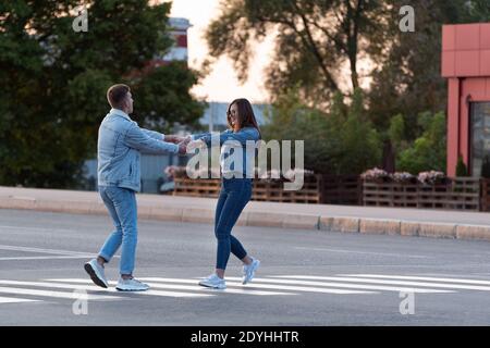 Couple amoureux danse sur la traversée piétonne, en tenant les mains Banque D'Images