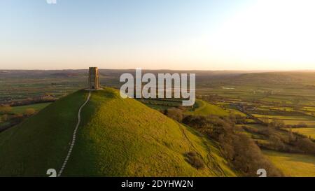 Vue aérienne du lever du soleil matinal au-dessus de Glastonbury Tor avec les champs Somerset ci-dessous. Banque D'Images