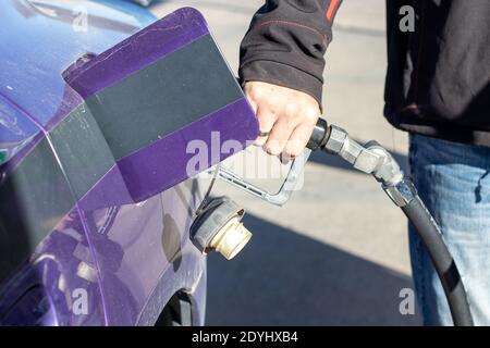 Homme tenant la pompe à gaz remplissage voiture avec gaz gros plan . Photo de haute qualité Banque D'Images