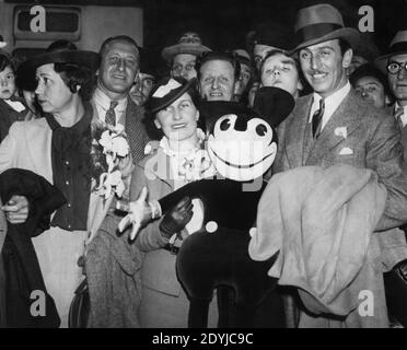 WALT DISNEY et sa femme LILLIAN MARIE S'EN SONT MIS À LA LIMITE Arrivée pour une visite en Grande-Bretagne à la gare de Paddington à Londres Juin 1935 tenue d'un jouet doux Mickey Mouse Banque D'Images