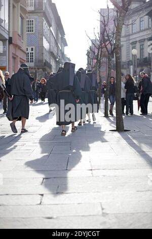 Braga, Portugal - 1er avril 2010: De sinistres figures traditionnelles vêtues de noir, appelées 'farricocos', avec les bruits de cliquetis sur leurs épaules, flânent Banque D'Images