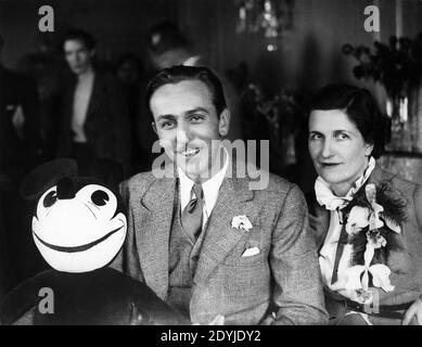 WALT DISNEY et sa femme LILLIAN MARIE S'EN SONT MIS À LA LIMITE Une visite en Grande-Bretagne à la réception de presse à leur arrivée À Londres juin 1935 tenue d'un jouet doux Mickey Mouse Banque D'Images