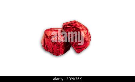 Bonbons en forme de coeur au chocolat doux enveloppés de papier d'aluminium rouge sur fond blanc. Photo de haute qualité Banque D'Images