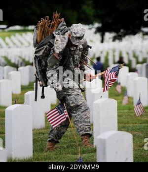 Soldat dans le troisième Régiment d'infanterie des États-Unis (la vieille garde) Placez un petit drapeau américain d'un pied devant et centré avant chaque repère de tombe pour plus de 220,000 tombes pendant la cérémonie annuelle des drapeaux-dans avant le jour du souvenir pour honorer les membres morts de la nation de l'armée le 23 2013 mai à Arlington Cemetery, Virginie, États-Unis. Photo par Olivier Douliery/ABACAPRESS.COM Banque D'Images