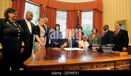 LE président AMÉRICAIN Barack Obama fait des remarques avant de signer un projet de loi dans le Bureau ovale, le 24 mai 2013 à Washington, DC, États-Unis, désignant la Médaille d'or du Congrès commémorant la vie des quatre jeunes filles tuées dans les attentats à la bombe de la 16e rue de l'église baptiste de 1963 à Birmingham, Alabama. Témoin (G-D) chirurgien général Regina Benjamin, Birmingham Maire William Bell, Dr Sharon Malone Titulaire, Procureur général Eric Holder, Rep Terri Sewell (D-AL), Thelma Pippen McNair (mère de Denise McNair), Lisa McNair (sœur de Denise McNair), Dianne Braddock (sœur de Carole Robertson), Rev Arthur Pric Banque D'Images