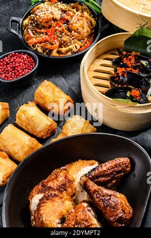 Plats chinois, fond noir. Nouilles chinoises, boulettes, canard de pékin, dim sum, rouleaux de printemps. Célèbre. Vue de dessus Banque D'Images