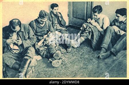 EUROPE DE L'EST - 1944: Prisonniers de guerre allemands en temps de silence. Temps de réparation des vêtements. Soldats allemands dans le camp de prisonniers de guerre. Archiver la photo en noir et blanc Banque D'Images