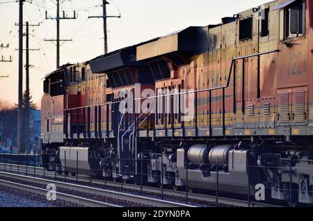 Bartlett, Illinois, États-Unis. Deux locomotives Burlington Northern Santa Fe dirigent un train de marchandises du chemin de fer canadien Pacifique jusqu'au dernier feu de la journée. Banque D'Images