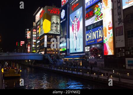 Panneaux d'affichage éclairés sur le pont bondé d'Ebisubashi sur le canal de Dotonbori la nuit. Banque D'Images