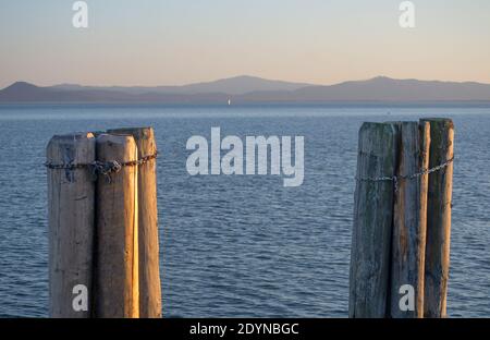 gros plan de la jetée en bois pour amarrer les bateaux dans le lac italien Trasimeno au coucher du soleil Banque D'Images