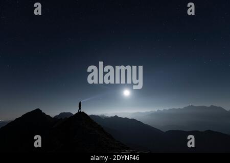 Alpiniste sur crête de sommet avec pleine lune et ciel étoilé, en arrière-plan Alpes Ammergau, Reutte, Alpes Ammergau, Tyrol, Autriche Banque D'Images