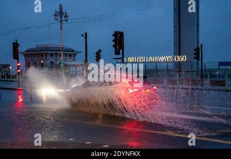 Brighton Royaume-Uni 27 décembre 2020 - UNE voiture traverse des inondations sur le front de mer de Brighton tôt dans la matinée, alors que Storm Bella battant la Grande-Bretagne aujourd'hui avec de forts vents et de fortes pluies causant des inondations et des dommages dans certaines régions : crédit Simon Dack / Alay Live News Banque D'Images