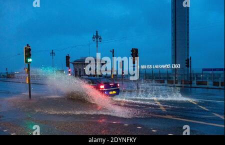 Brighton Royaume-Uni 27 décembre 2020 - UNE voiture traverse des inondations sur le front de mer de Brighton tôt dans la matinée, alors que Storm Bella battant la Grande-Bretagne aujourd'hui avec de forts vents et de fortes pluies causant des inondations et des dommages dans certaines régions : crédit Simon Dack / Alay Live News Banque D'Images