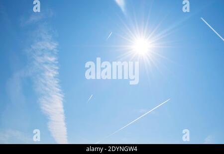 Chemins dans le ciel lors d'une journée ensoleillée. Photo de la théorie du complot de la vapeur de jet et de l'empreinte carbone réalisée par des avions commerciaux. Circulation aérienne très fréquentée Banque D'Images