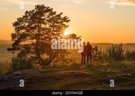 Un jeune couple admire le coucher du soleil d'été sur le mont Paasonwoori. Sortavala, Carélie Banque D'Images