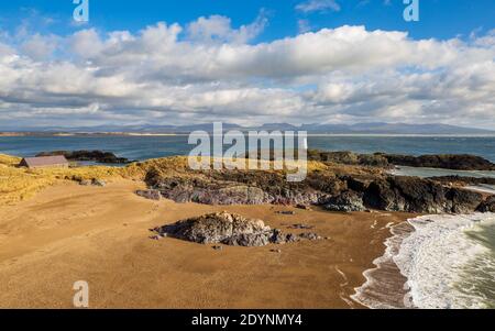 Vue sur Twr Bach et les montagnes de Snowdonia à travers Porth Twr Mawr sur l'île de Llanddwyn, Anglesey Banque D'Images