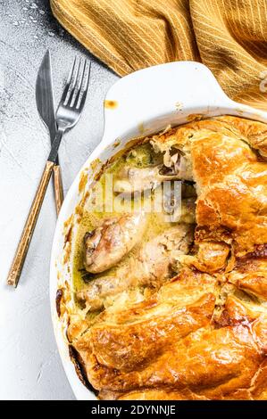 Copieuse tarte au poulet maison avec petits pois et carottes. Arrière-plan gris. Vue de dessus Banque D'Images