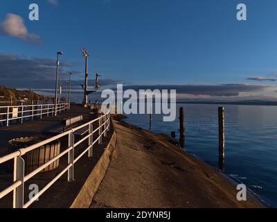 Jetée de la ville de Meersburg, Allemagne sur la rive du lac de Constance dans la belle lumière du soir avec des montagnes enneigées à l'horizon en hiver. Banque D'Images