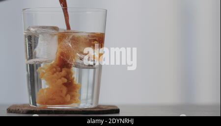 versez l'espresso dans du soda transparent ou du tonique pour faire un espresso tonique sur le plan de travail en béton avec espace de copie, photo large Banque D'Images