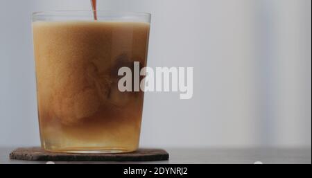 versez l'espresso dans du soda transparent ou du tonique pour faire un espresso tonique sur le plan de travail en béton avec espace de copie, photo large Banque D'Images