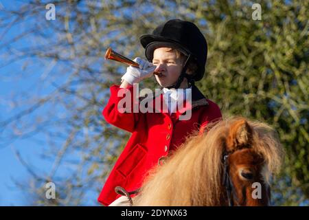 Arley, Worcestershire, Royaume-Uni. 27 décembre 2020. En raison des chasses peu importantes du lendemain de Noël dues aux restrictions de Covid, Henley Mills, 7 ans, se met à faire sa propre « chasse » ce matin. Vêtu d'une tunique rouge, d'un casque et d'une assise magistrale sur son mont Radish - un poney de 7 ans - Henley a un moment de gloire. Henley et sa famille, d'Arley dans le Worcestershire, auraient normalement assisté à la chasse aux bois et à l'Albrighton à Hagley Hall, mais des spectateurs et des suiveurs étaient absents en raison des règles de Covid, ce qui l'a laissé déçu. Crédit : Peter Lophan/Alay Live News Banque D'Images