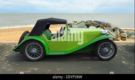 Classic Green MG voiture de sport garée sur la promenade du front de mer avec la plage et la mer en arrière-plan. Banque D'Images