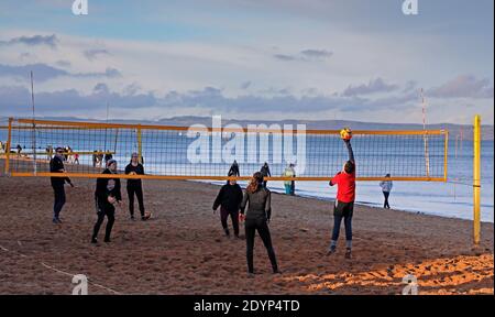 Portobello, Édimbourg, Écosse, Royaume-Uni. 27 décembre 2020. Soleil dans la température de l'après-midi de 3 degrés centigrade, occupé avec les gens dehors marche et l'exercice. Photo : jeunes jouant au volley-ball sur la plage de sable. Crédit : Arch White/Alamy Live News. Banque D'Images