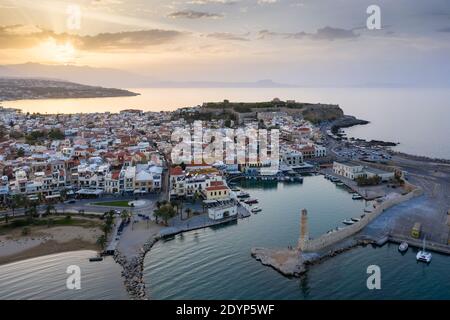 Vue aérienne de la ville de Réthymnon au coucher du soleil montrant le vieux port vénitien, le phare, la vieille ville et le château de Fortezza, Crète, Grèce Banque D'Images