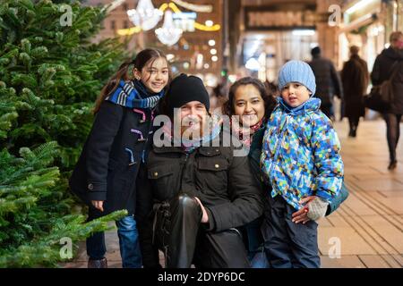 Bonne famille multinationale en plein air dans un centre-ville à Noël Banque D'Images