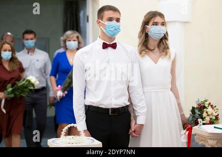 Mariage. Mariée et marié portant des masques médicaux. Se marier pendant la pandémie du coronavirus. Banque D'Images