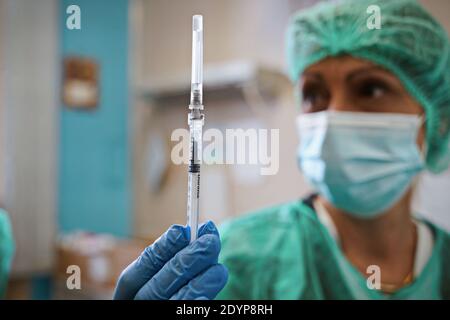 Gros plan main d'une femme médecin portant un masque de protection en laboratoire tenir la seringue avec le vaccin coronavirus de Pfizer, à l'hôpital Amedeo di Savoia. Tu Banque D'Images