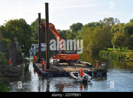 Réparations à la rive de la rivière Great Ouse à St Neots Cambridgeshire équipement sur ponton flottant utilisé pour conduire dans les aciers. Banque D'Images