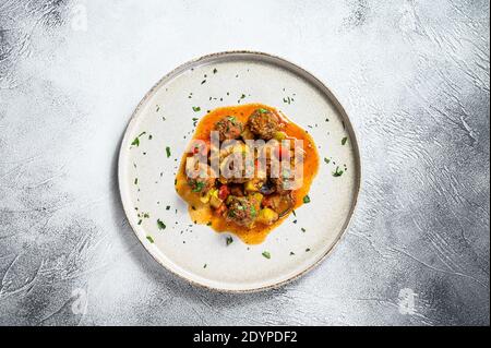 Délicieux boulettes de viande faites de bœuf haché dans une sauce tomate, servies dans une vieille casserole en métal. Arrière-plan gris. Vue de dessus Banque D'Images