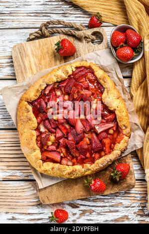 Galette avec fraise et rhubarbe. Tarte maison, tarte. Fond en bois blanc. Vue de dessus Banque D'Images