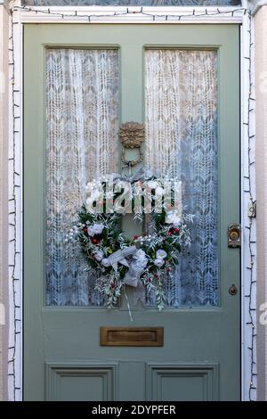 Une décoration de couronne de Noël accrochée sur la porte avant de une maison Banque D'Images