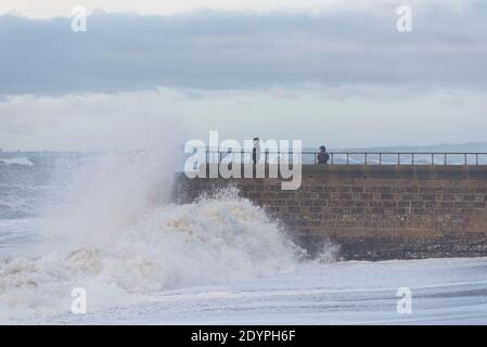 Brighton, East Sussex. 27 décembre 2020. Météo Royaume-Uni. Les vestiges de la tempête Bella battent la côte sud avec d'énormes vagues qui s'écrasent sur le front de mer de Brighton devant des spectateurs audacieux. Le bureau met a émis des avertissements météorologiques à travers le Royaume-Uni en raison de vents violents et d'inondations. Credit: Francesca Moore/Alamy Live News Banque D'Images