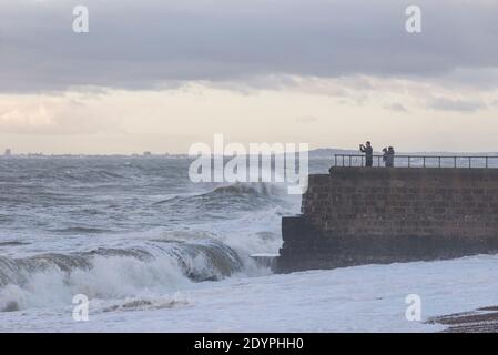 Brighton, East Sussex. 27 décembre 2020. Météo Royaume-Uni. Les vestiges de la tempête Bella battent la côte sud avec d'énormes vagues qui s'écrasent sur le front de mer de Brighton devant des spectateurs audacieux. Le bureau met a émis des avertissements météorologiques à travers le Royaume-Uni en raison de vents violents et d'inondations. Credit: Francesca Moore/Alamy Live News Banque D'Images